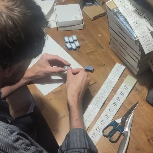 Josha putting whiteboard stickers on the banners of our initiative tracker.