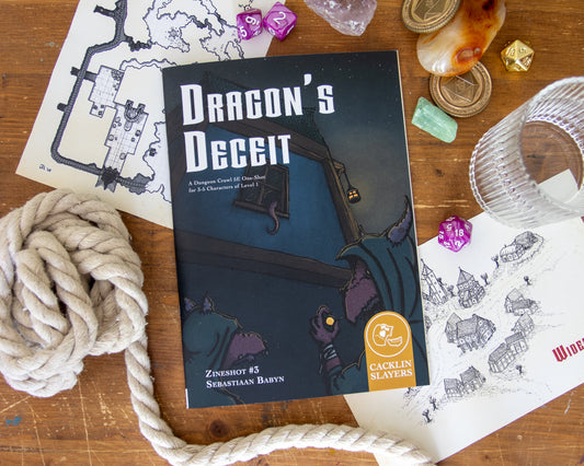 The zineshot Dragon's Deceit lies on a wooden table, surrounded by handouts, dice, gems, and other adventurous things.