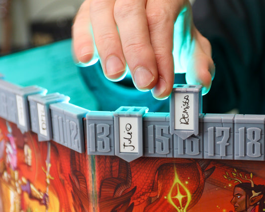 A hand places a character's banner on initiative count 16. The initiative tracker is mounted on the official D&D 5E 2024 DM screen.