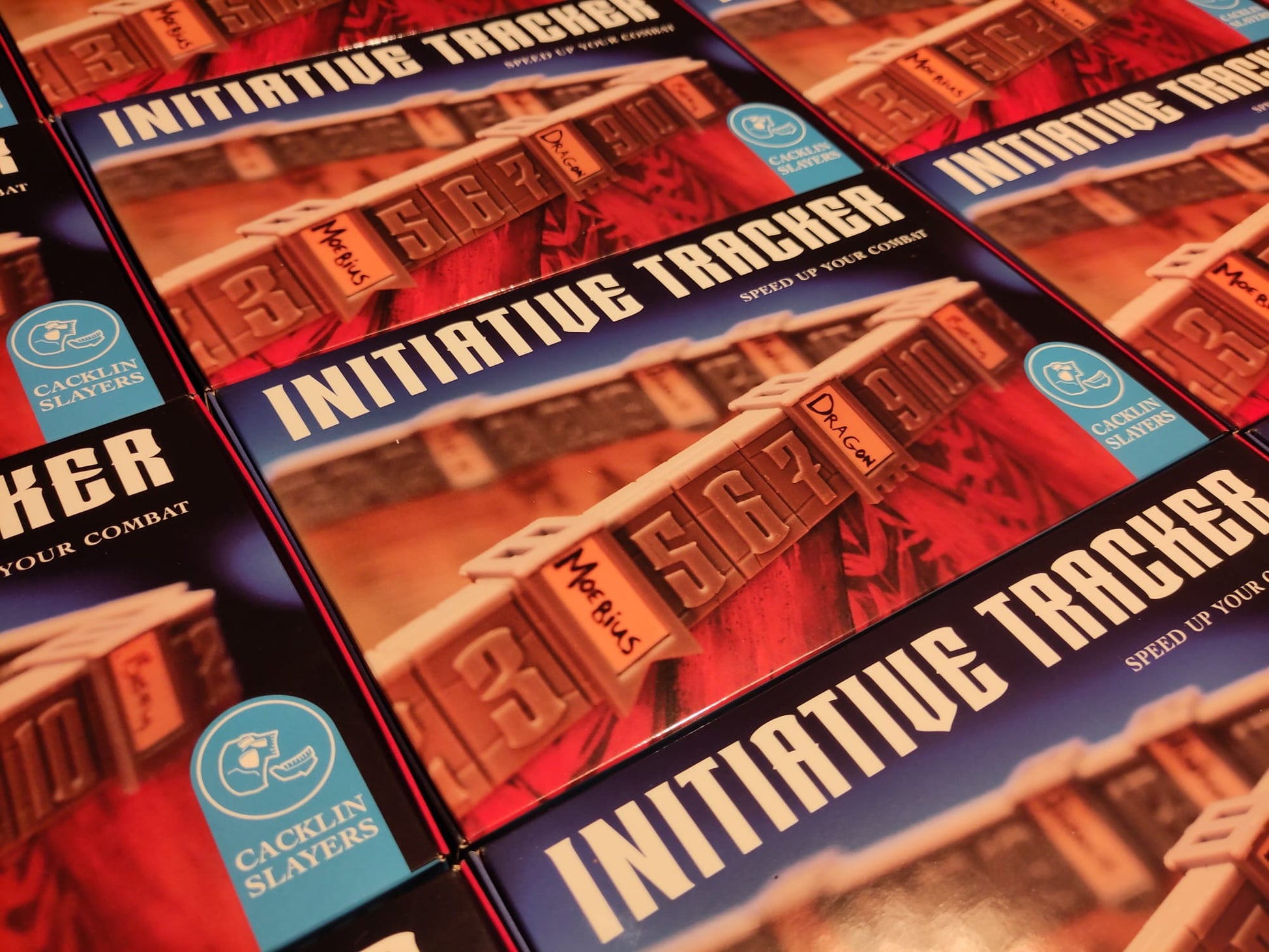 Multiple packages of Cacklin Slayers' Initiative Tracker. Beneath the title is a picture of the tracker mounted on a 2 mm Dungeon Master's Screen, along with the tagline 'SPEED UP YOUR COMBAT'.